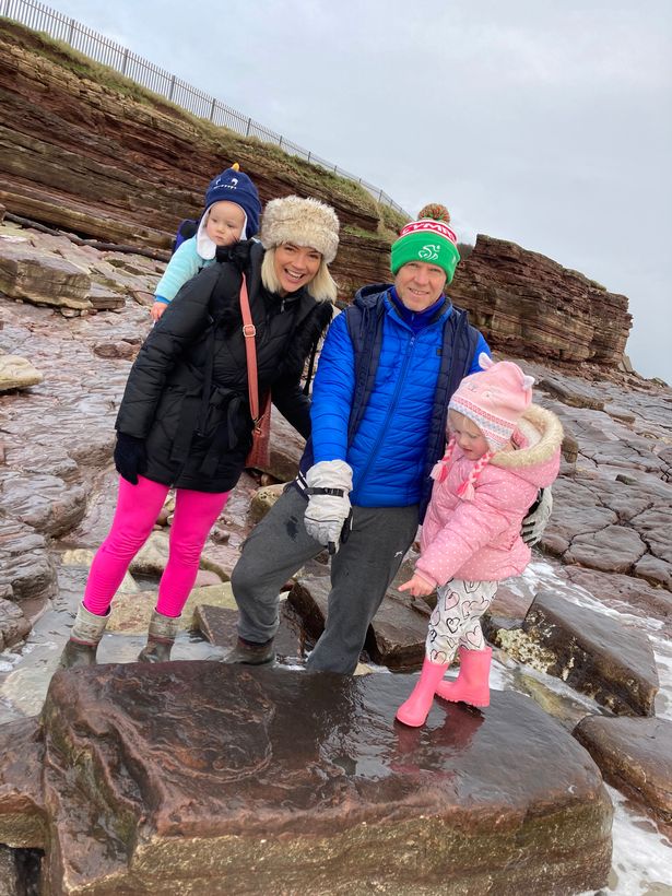 Lily Wilder with her mum Sally and dad Richard and the dinosaur footprint she found on Bendricks Bay Barry