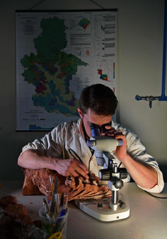Paleontologist Rodrigo Temp Muller examines a dinosaur fossil from the Triassic period at CAPPA, a Brazilian research support centre for paleontology in Sao Joao do Polesine, Brazil, on 2 December 2019. Photo: AFP