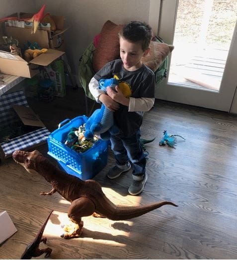 Riley Wooten, 4, with some of the dinosaurs strangers sent him after his home in Paradise, Calif., burned and he lost his collection. (Tanya Renfro)